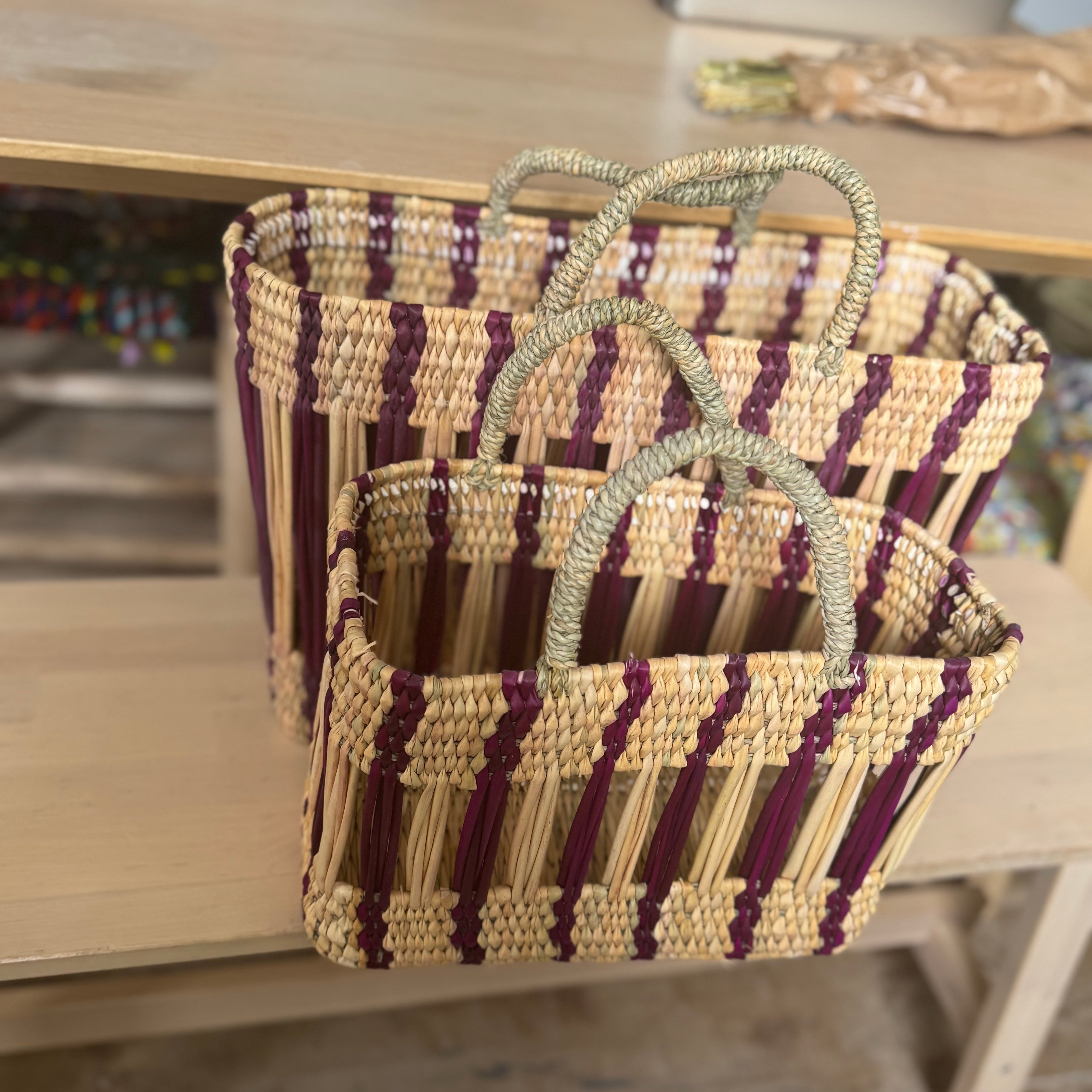 Woven bags with purple and beige stripes on a wooden surface.