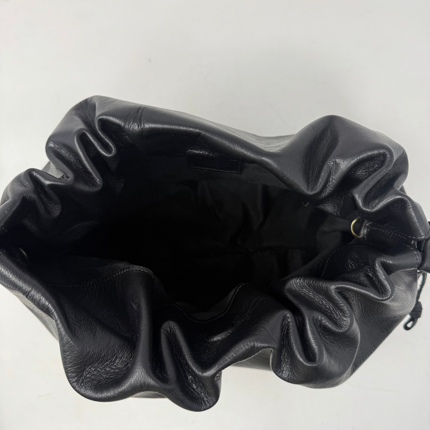 Black leather drawstring bag on a white background
