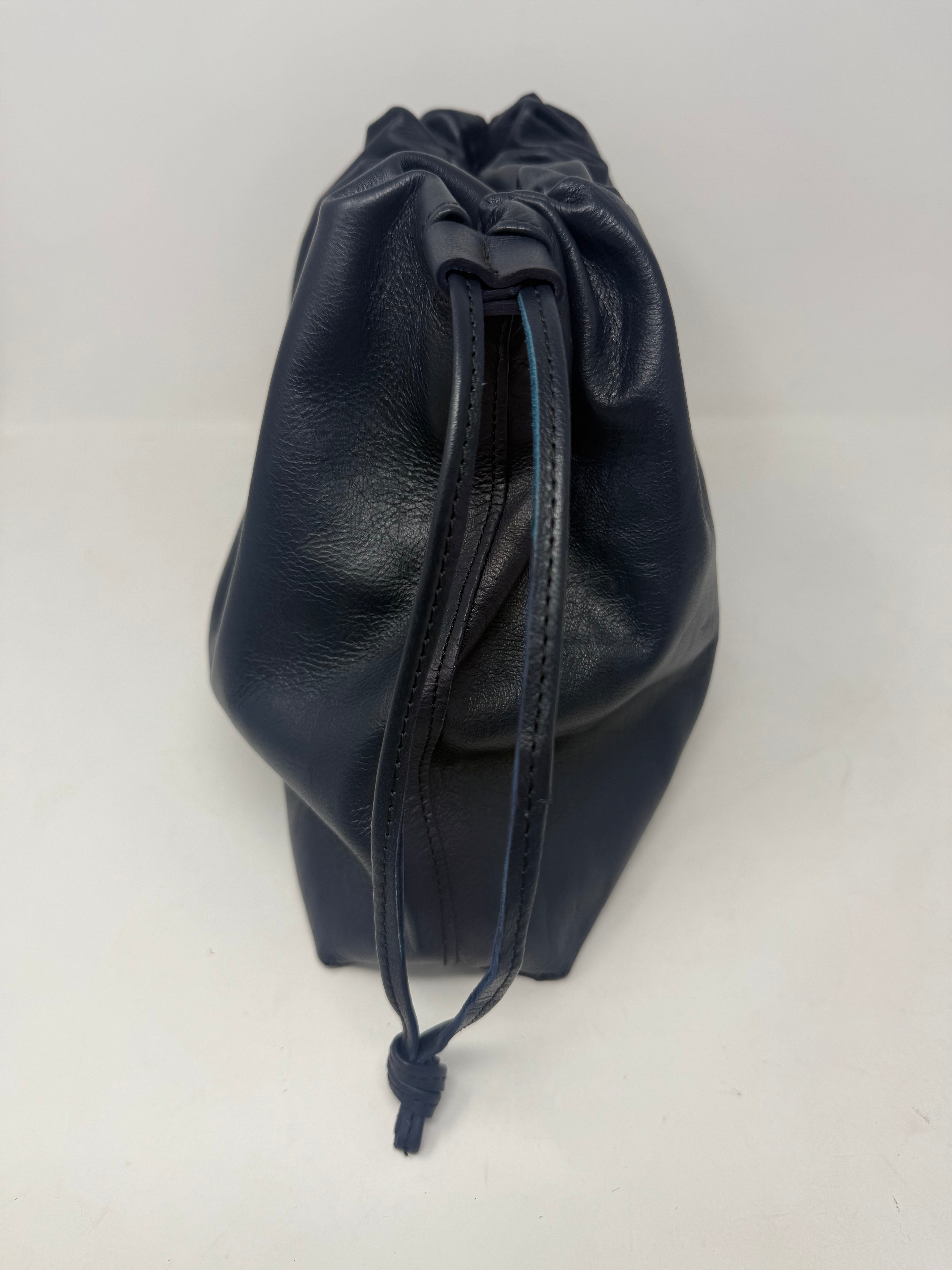 Black leather drawstring bag on a white background