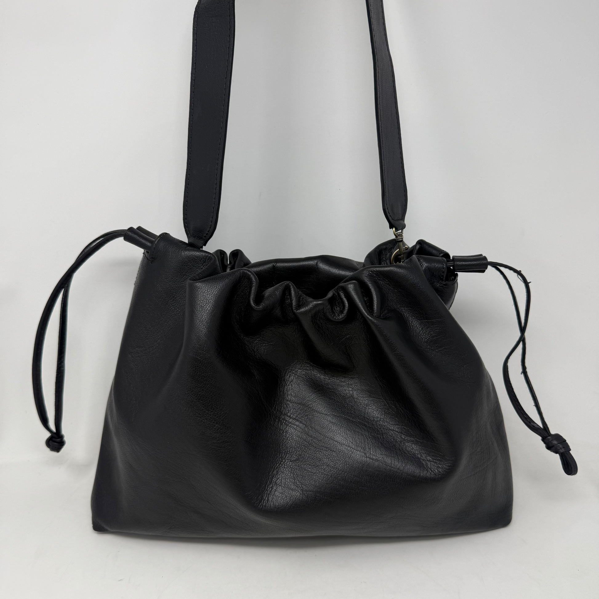 Black leather drawstring bag on a white background