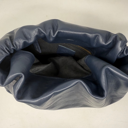 Blue leather bag on a beige background