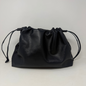 Black leather drawstring bag on a light gray background